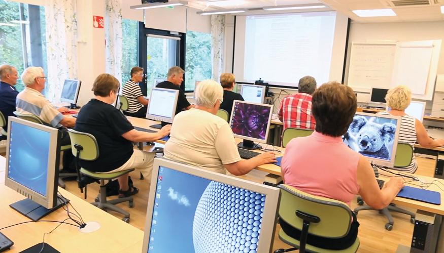 Eläkeläiset koneiden ääressä ATK-luokassa