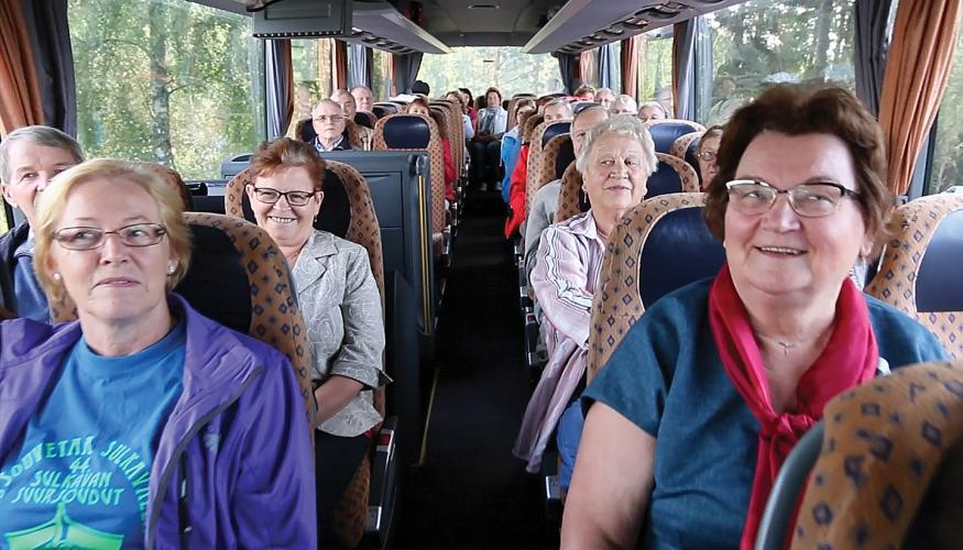 Eläkeläisiä istuu linja-autossa