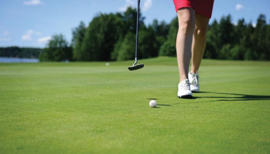 Naisen jalat golf-viheriöllä
