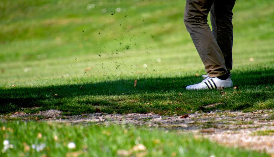 Golfin tiiauslyönti ja ruoho lentää